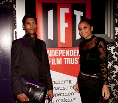 Emmanuel Ray and Karyn Louise at Independent Film Trust party.     Emmanuel Ray wears outfit by A. Hallucination. Bag by ARANGUIZ. 