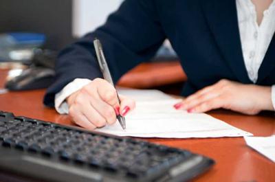 A secretary writes with a pen